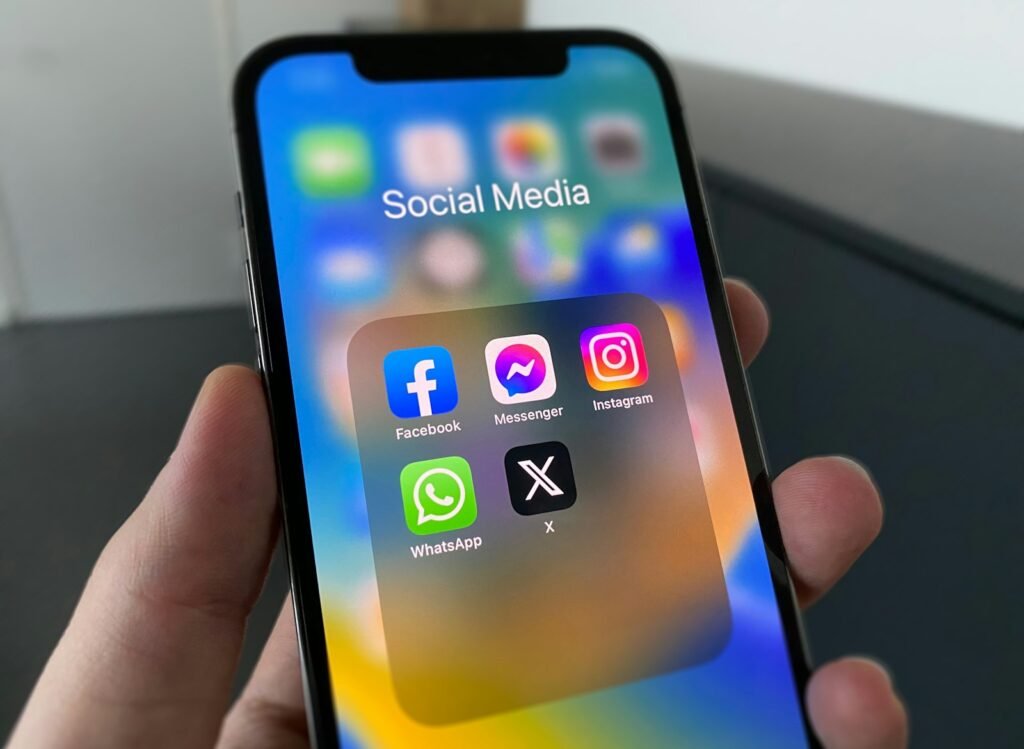 Person holding a smartphone showing a social media feed, ready to post a new phone status